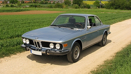 BMW 3.0 CSI in silberblau lackiert, parkt auf einem Feldweg.